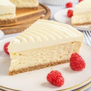 overhead shot of a whole vanilla bean cheesecake on a dessert stand, ready to be sliced