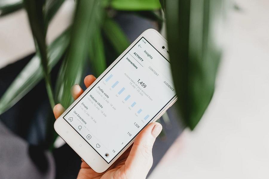 woman checking instagram analytics on her phone
