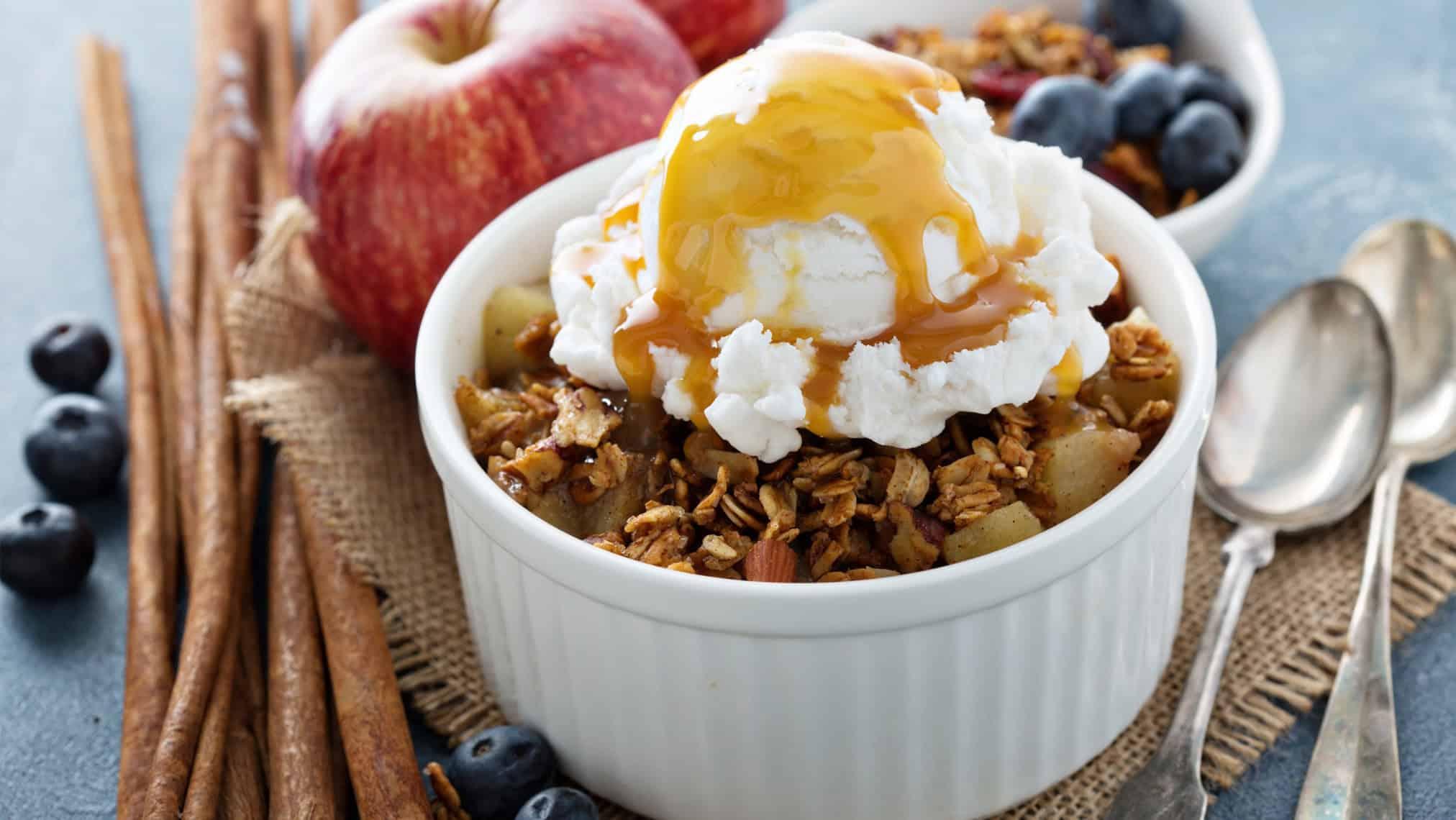 close-up of a slice of maple walnut apple crumble being served with vanilla ice cream