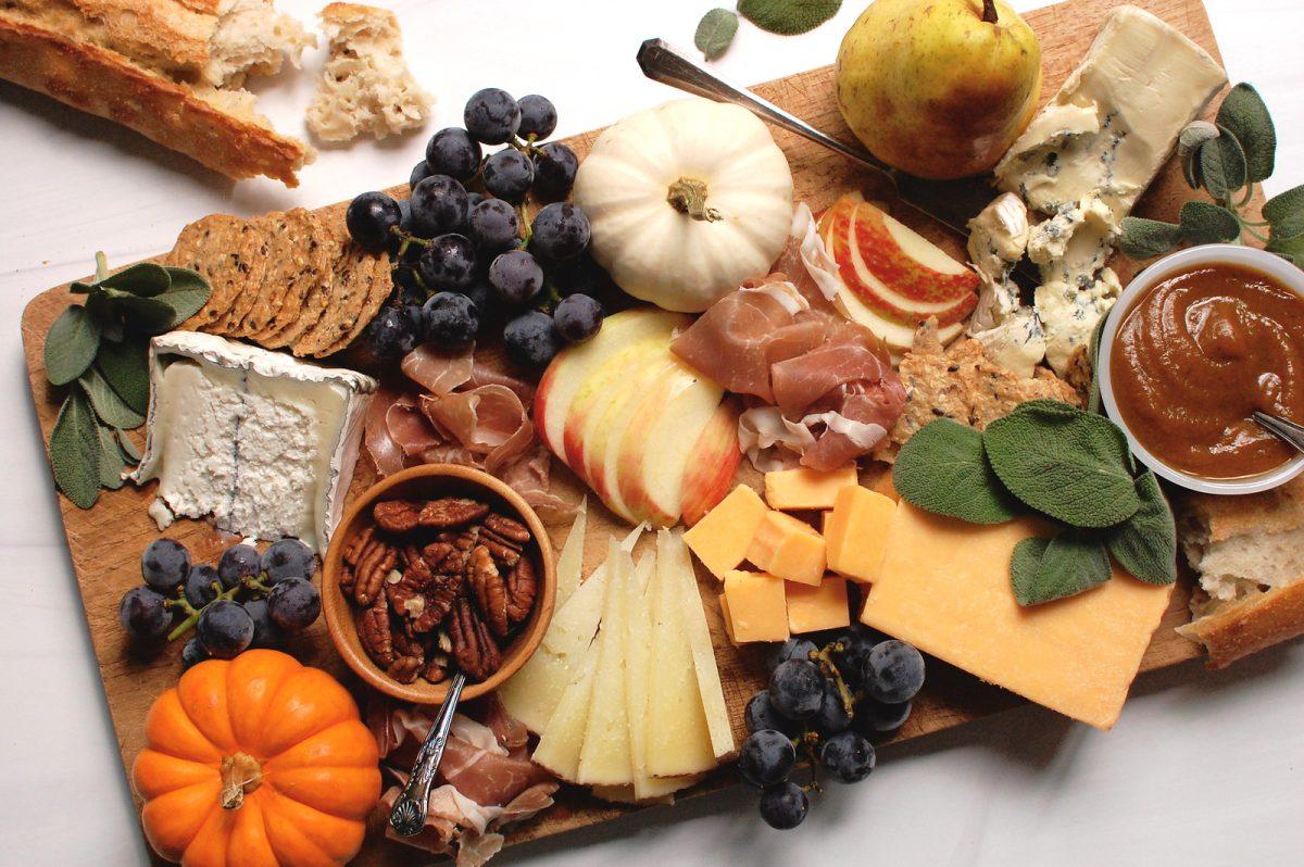 a charcuterie board featuring pumpkin spice rhubarb jam served with various cheeses, crackers, and fruits