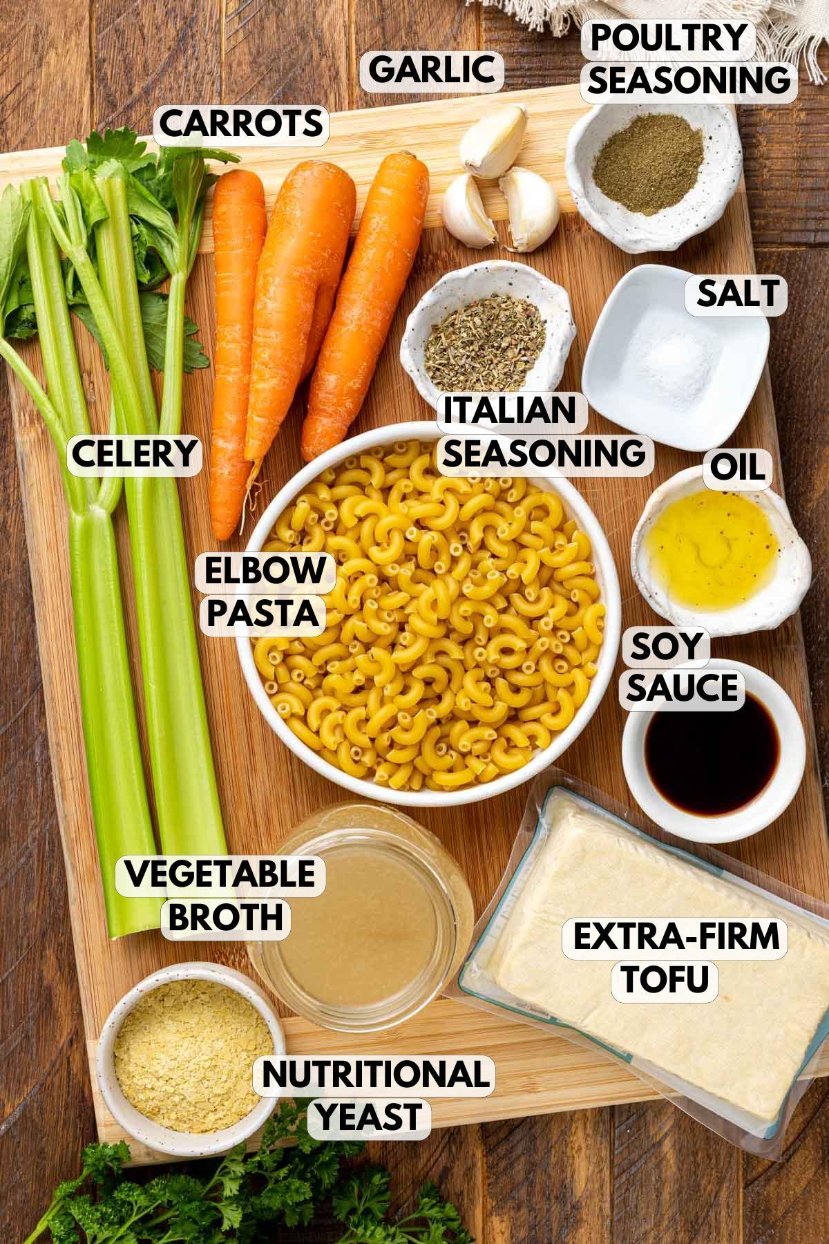 ingredients for chicken noodle soup laid out on a wooden table