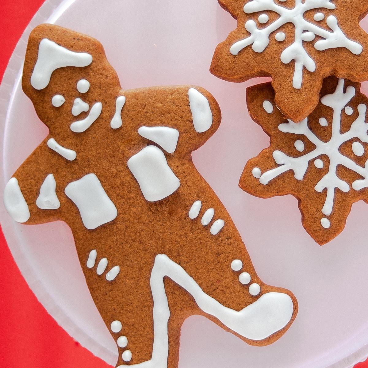 hands decorating gingerbread cookies with royal icing, vintage kitchen background