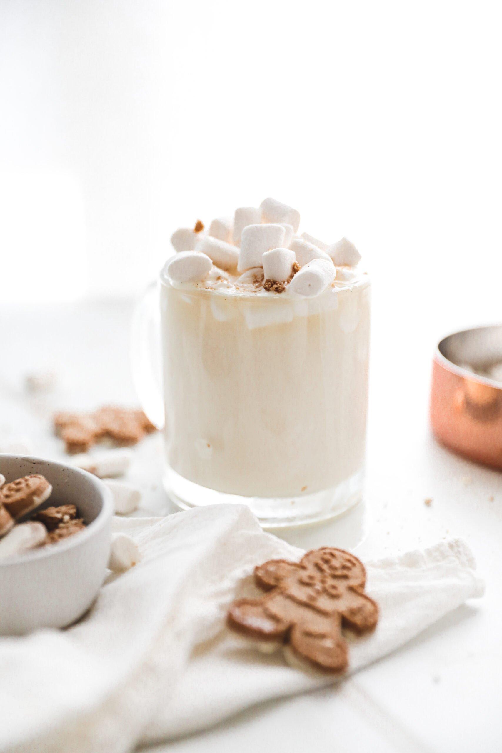 Elegant mug of white hot chocolate topped with marshmallows and a sprinkle of cocoa