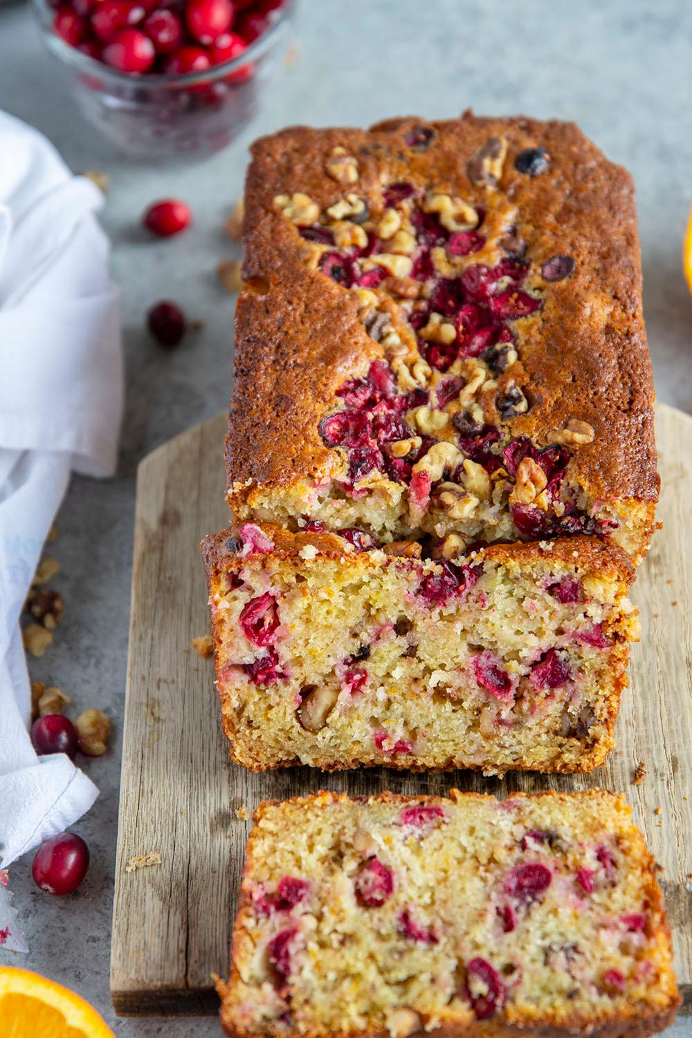 Close-up shot of a slice of cranberry orange bread showing cranberries and orange zest