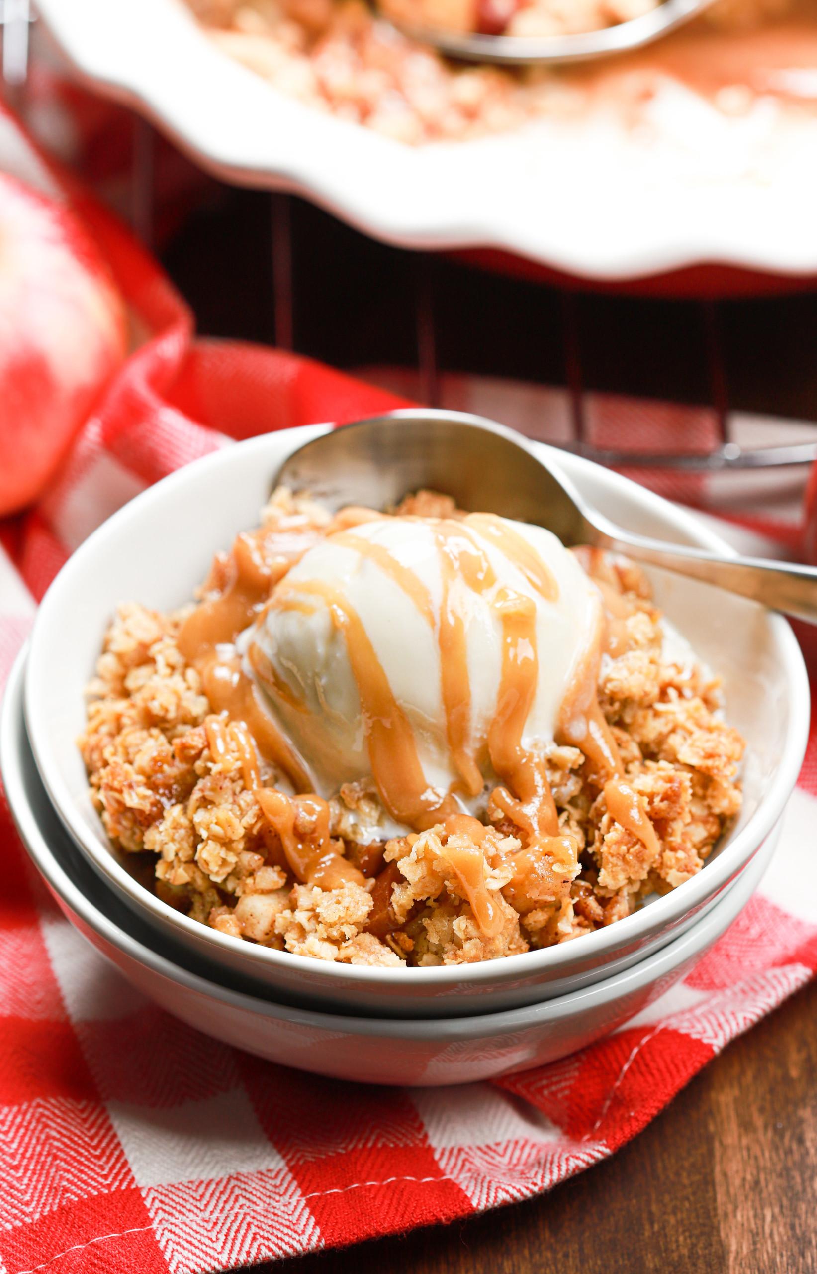 Homemade caramel sauce being drizzled over warm apple crisp, close-up