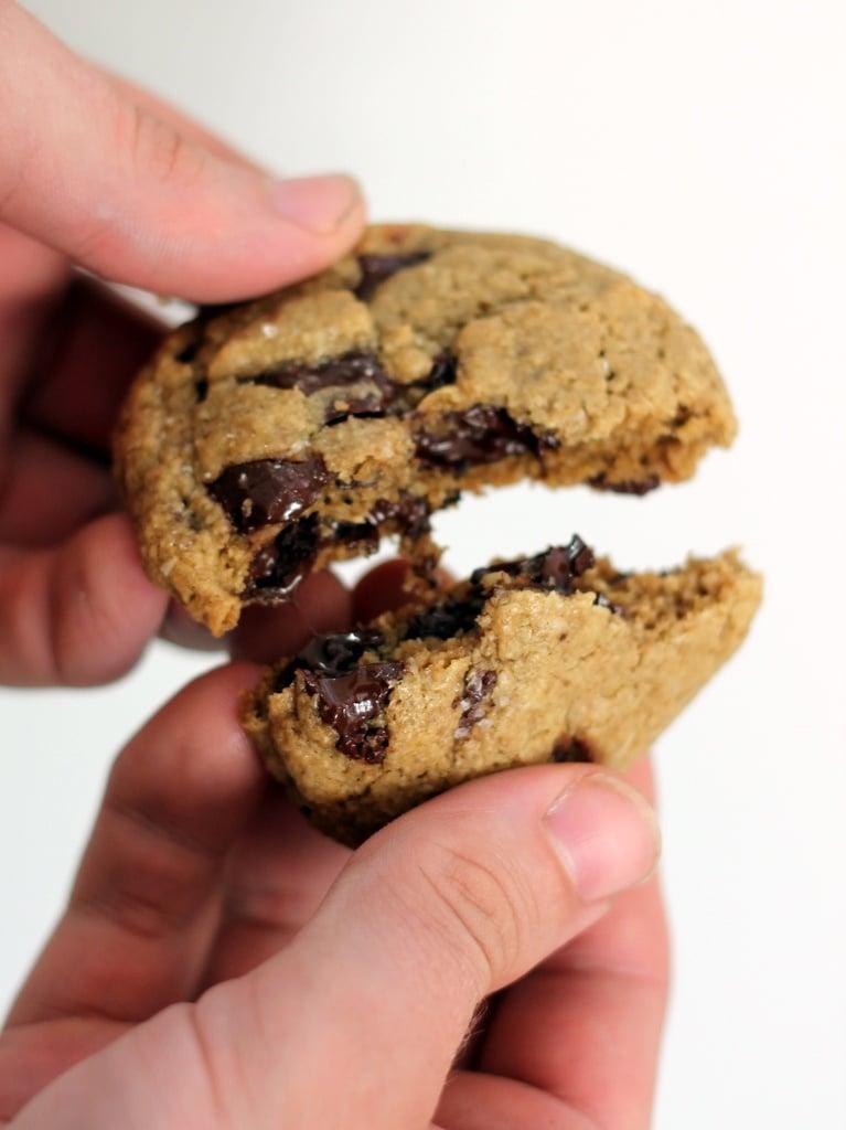hand breaking an oatmeal chocolate chunk cookie in half, showing melted chocolate
