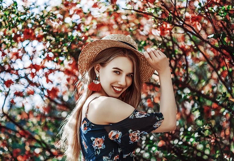 Woman wearing a pair of tassel earrings with a flowy summer dress