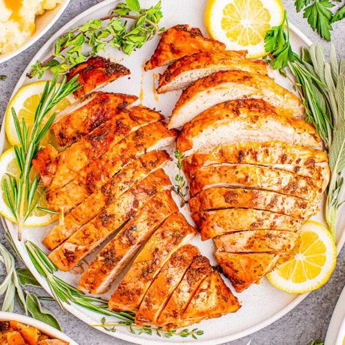 Finished pan-seared turkey breast drizzled with lemon butter, garnished with fresh parsley