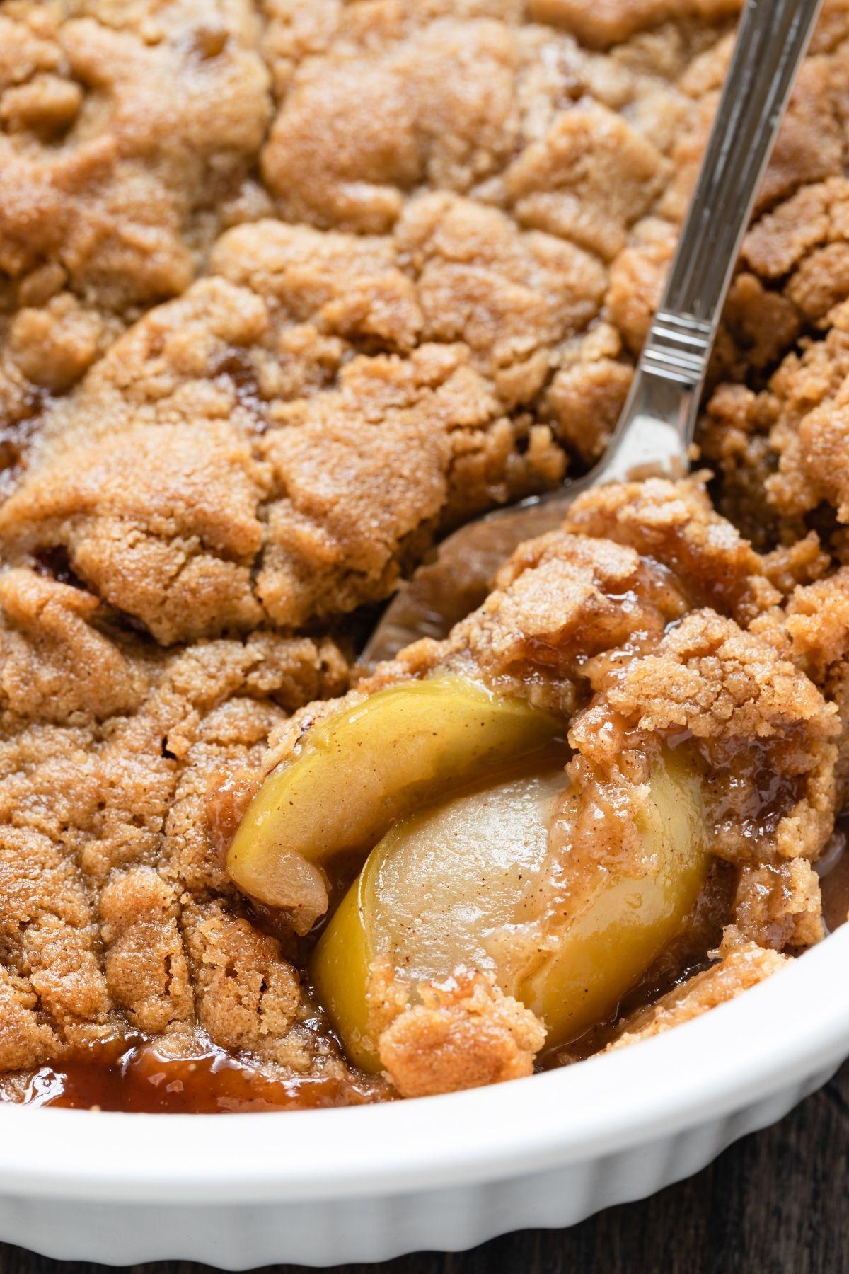Sliced apples tossed with cinnamon and sugar in a bowl, raw crumble topping