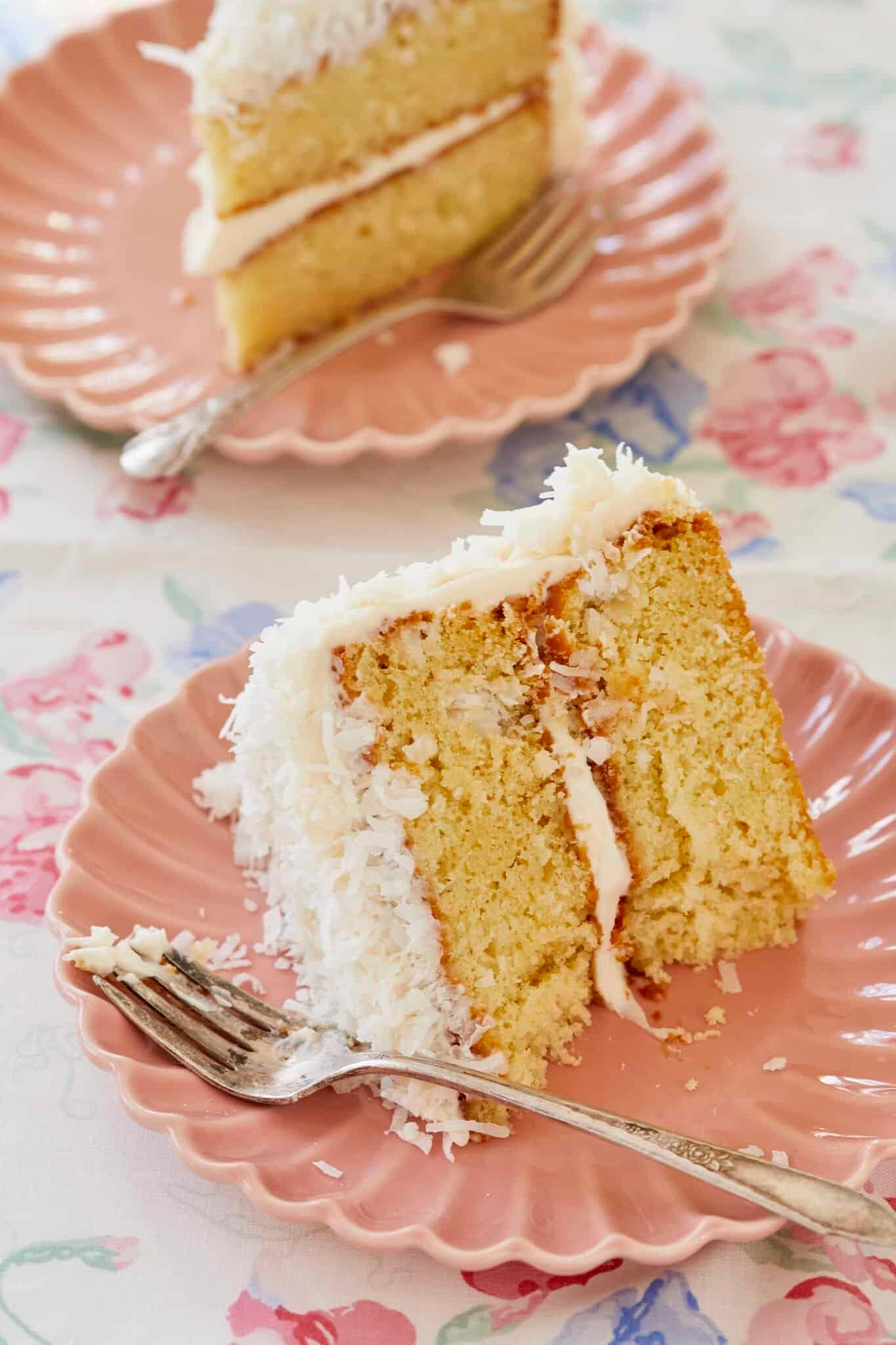 Close-up shot of a slice of vanilla cake showing the texture and coconut cream frosting