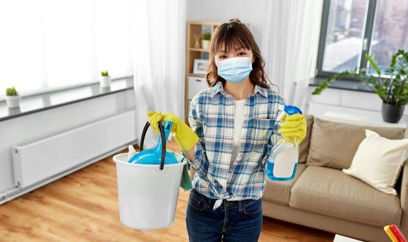 woman feeling sick while cleaning house with chemical products