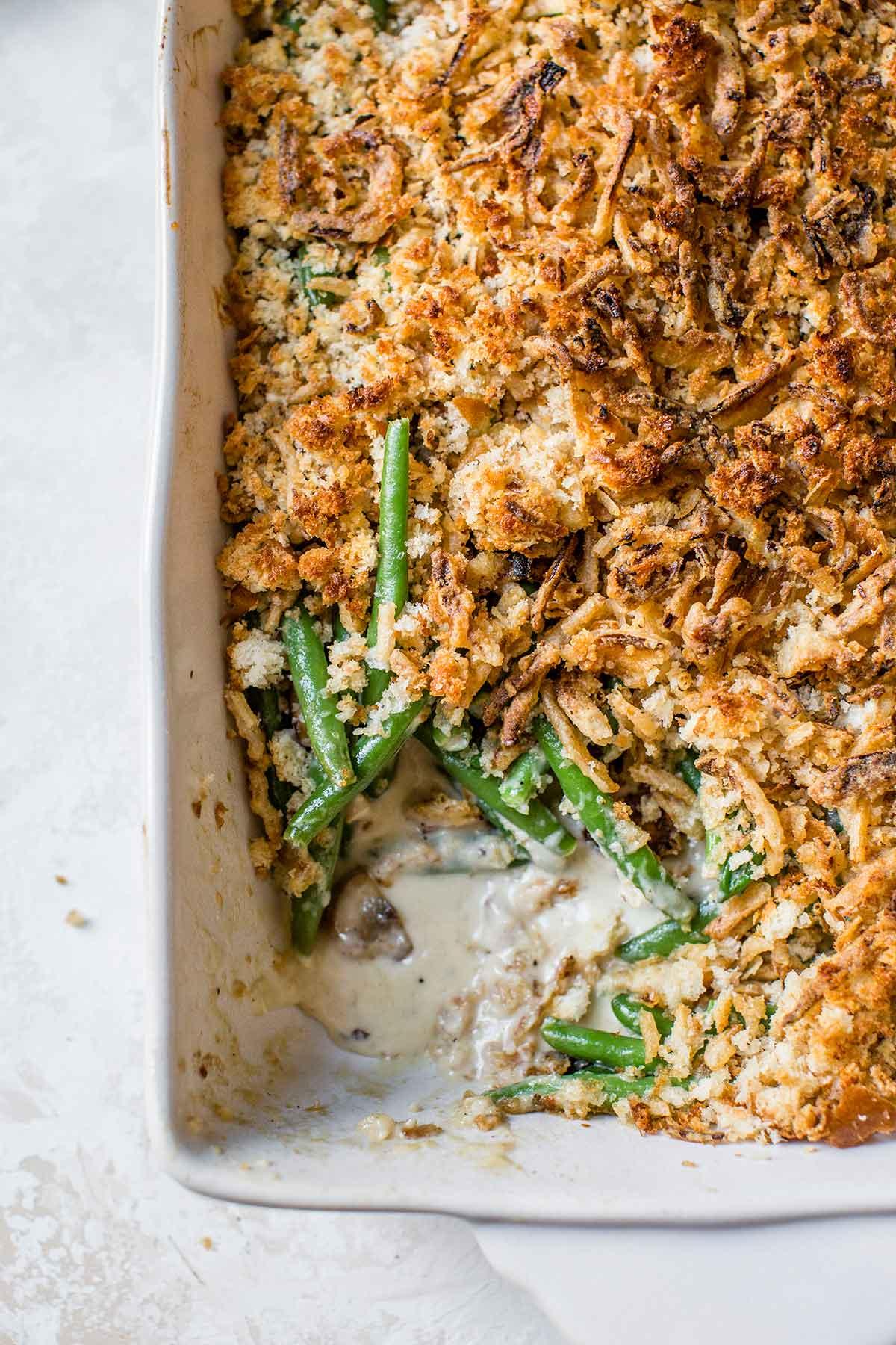 Overhead shot of an assembled Green Bean Parmesan Bake in a casserole dish, ready for baking.