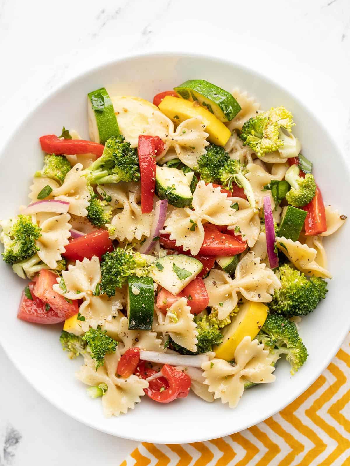 overhead shot of a colorful veggie pasta salad in a white bowl