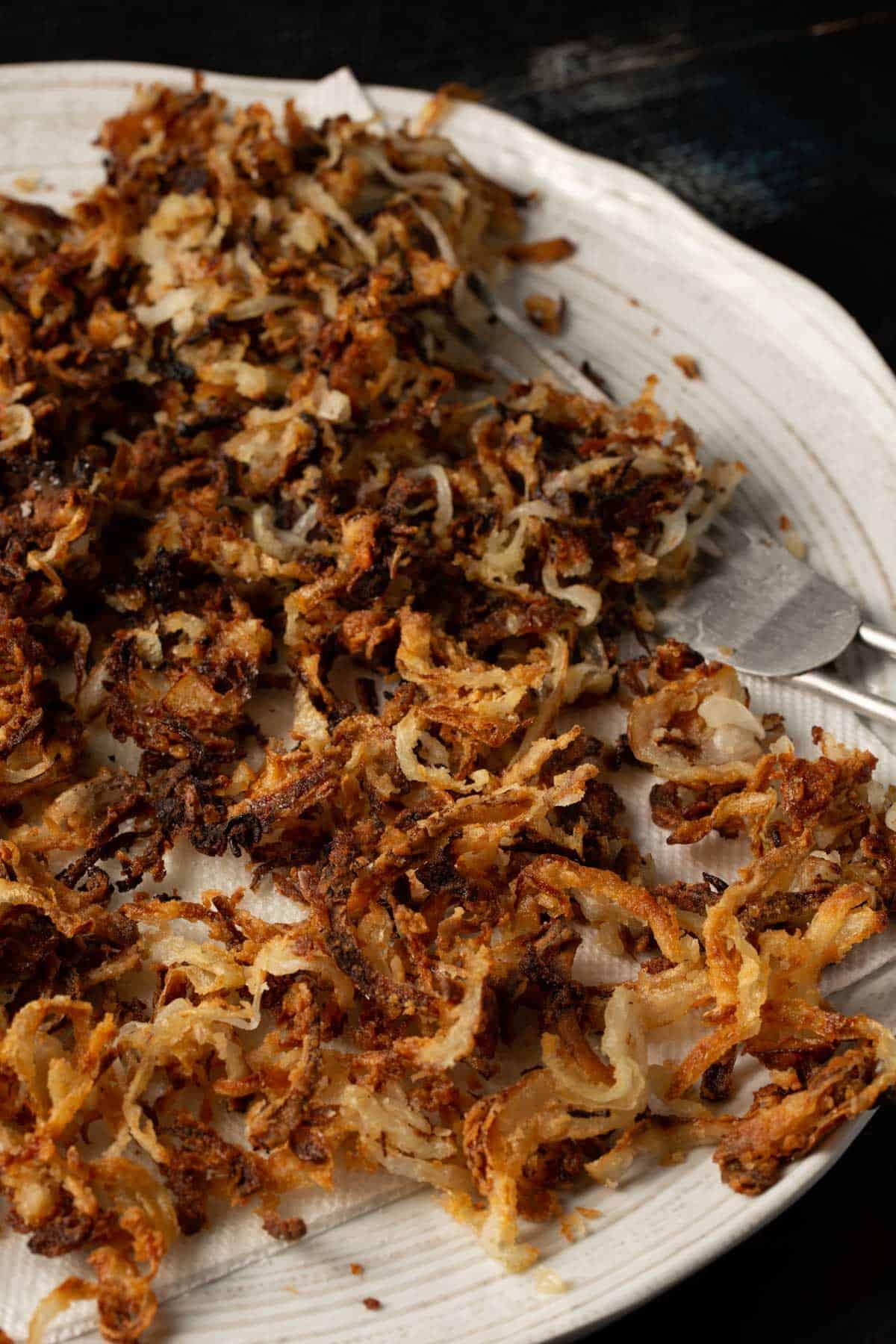 A bowl of homemade crispy fried onions, golden brown and perfectly seasoned
