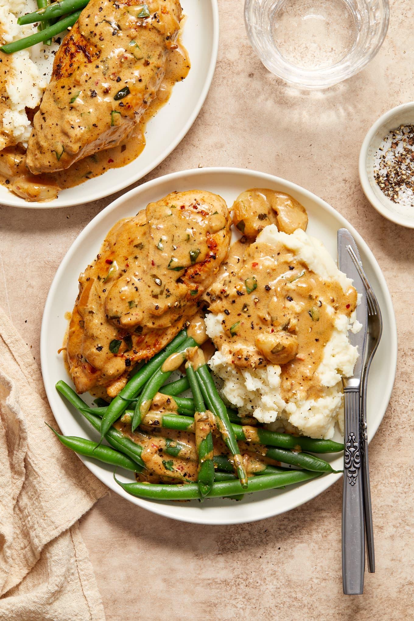 Perfectly seared golden chicken breast on a plate, drizzled with buttery pan sauce and fresh parsley, side of mashed potatoes