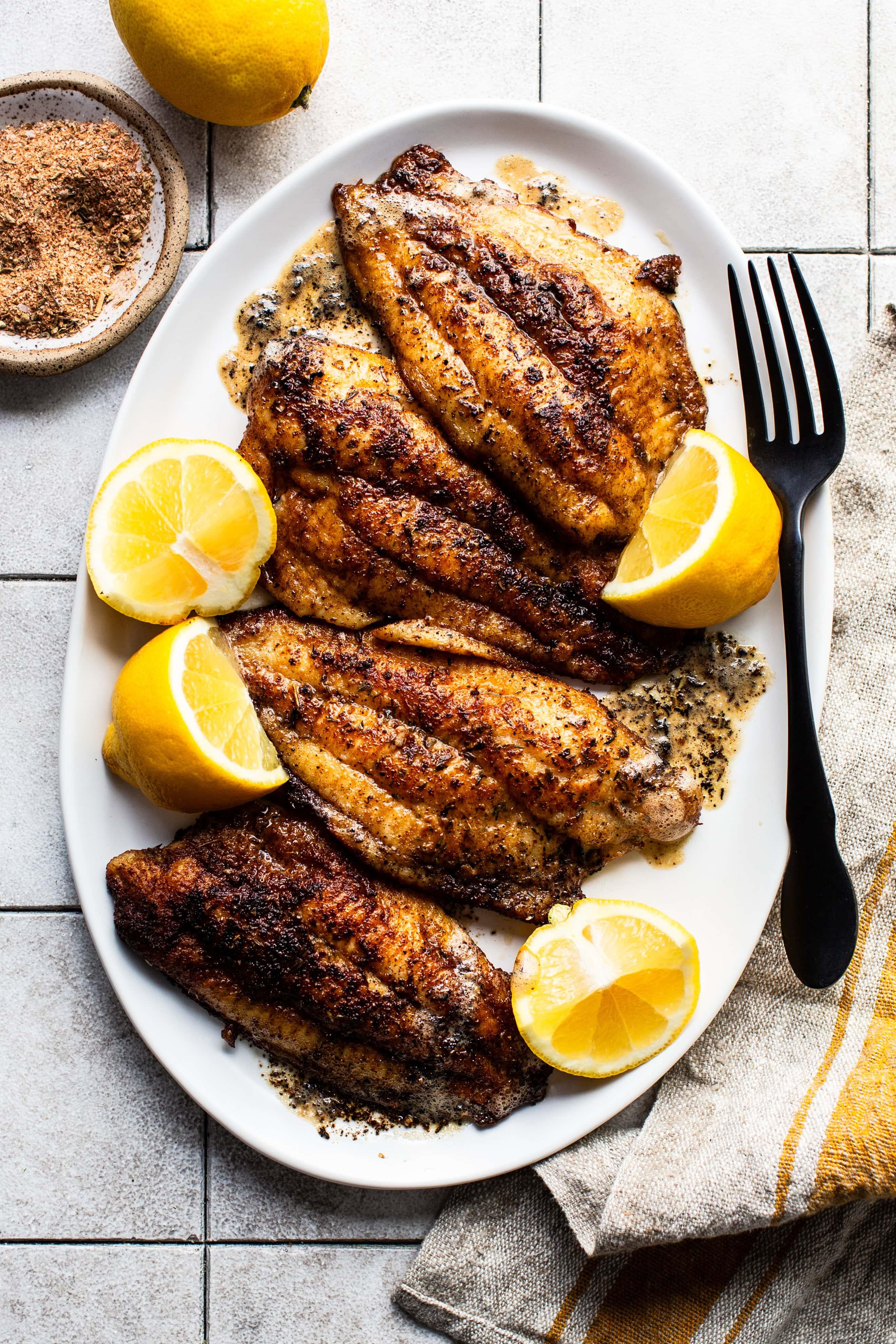 chef preparing blackened catfish in a cast iron skillet
