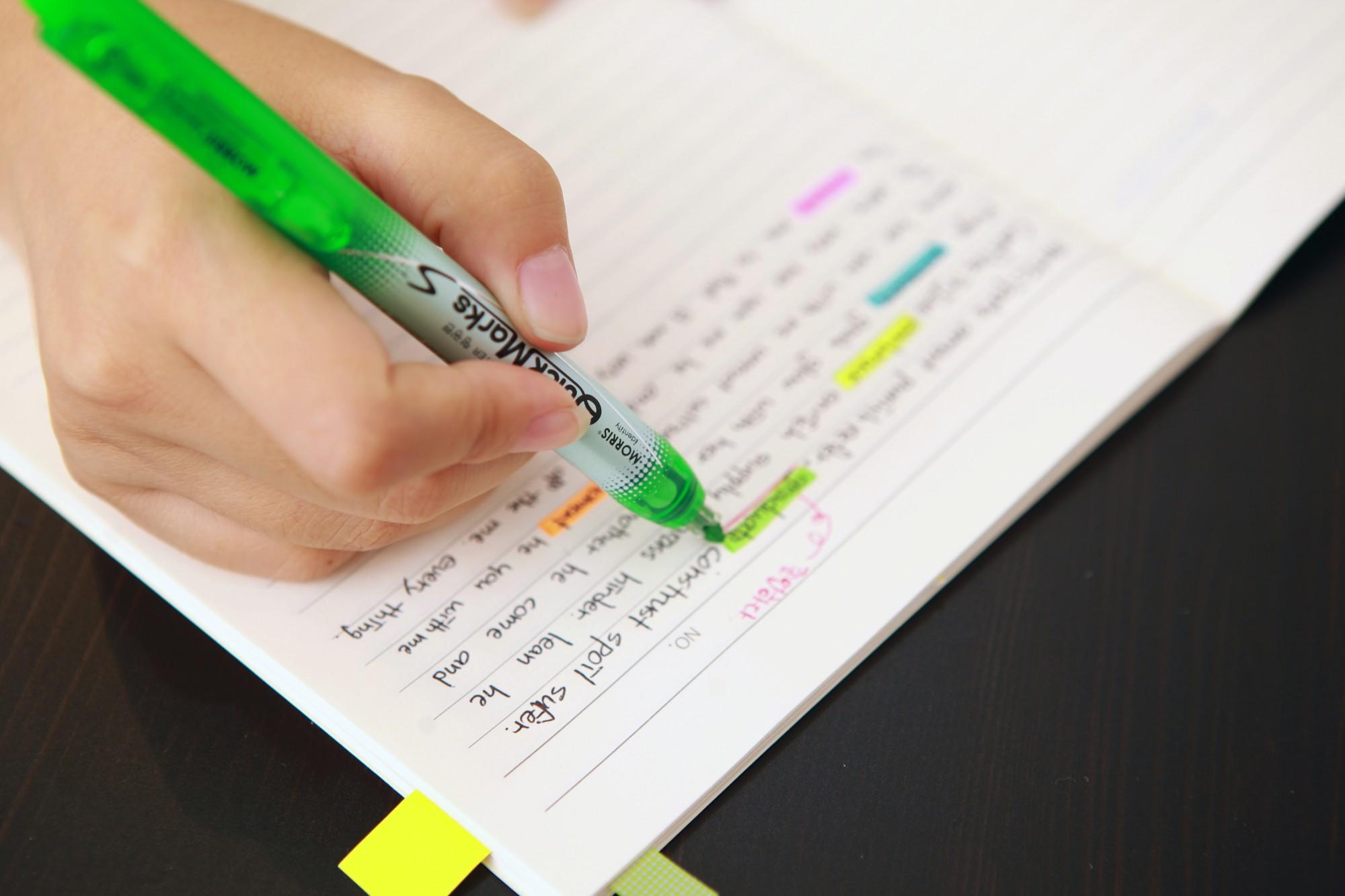 college student highlighting textbooks and notes