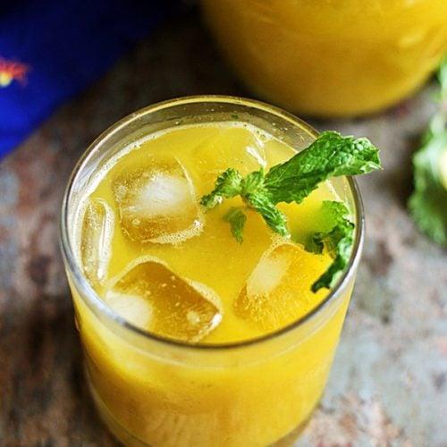 Person enjoying a mango mint cooler at a holiday gathering