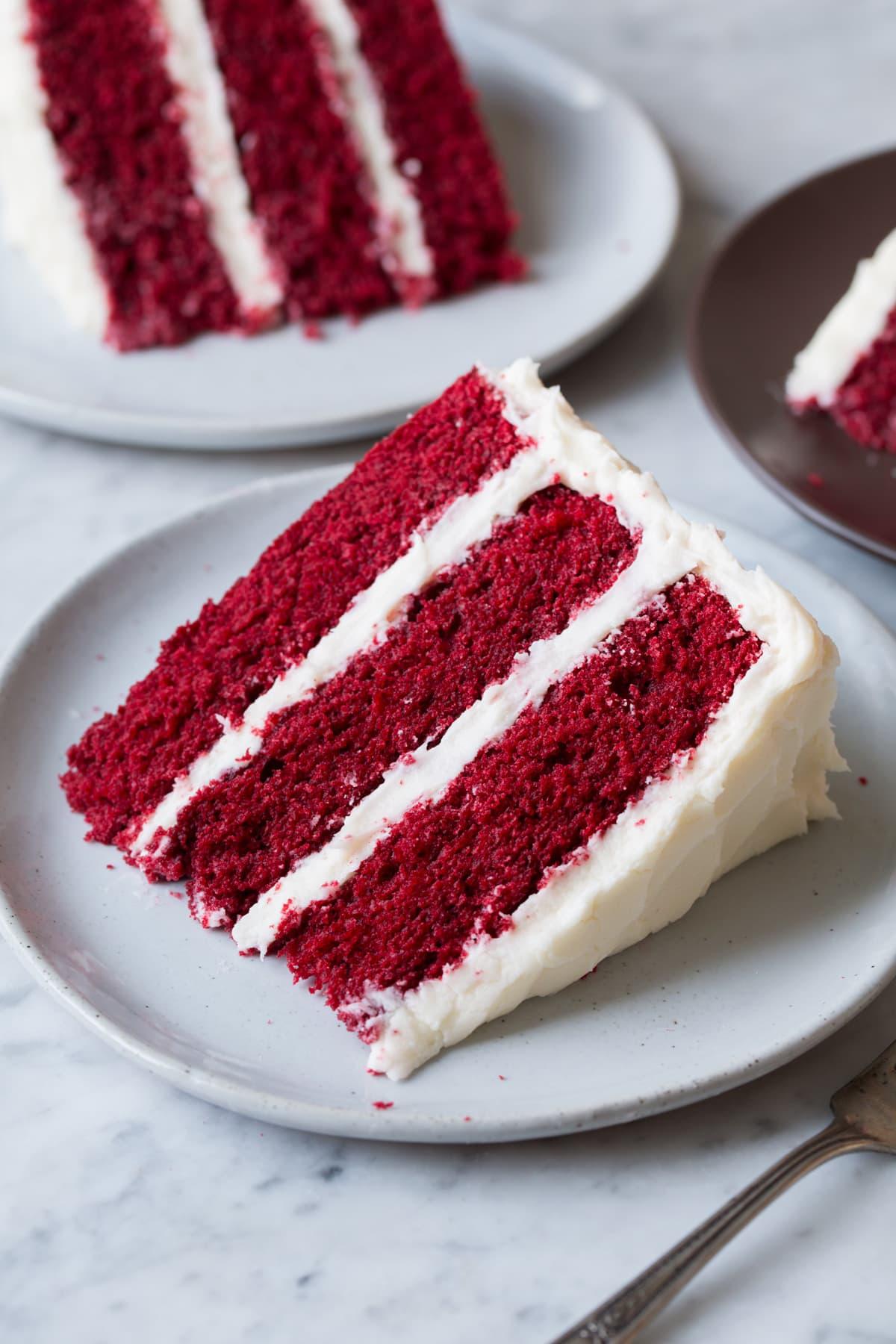 slices of red velvet cake on a plate with cream cheese frosting