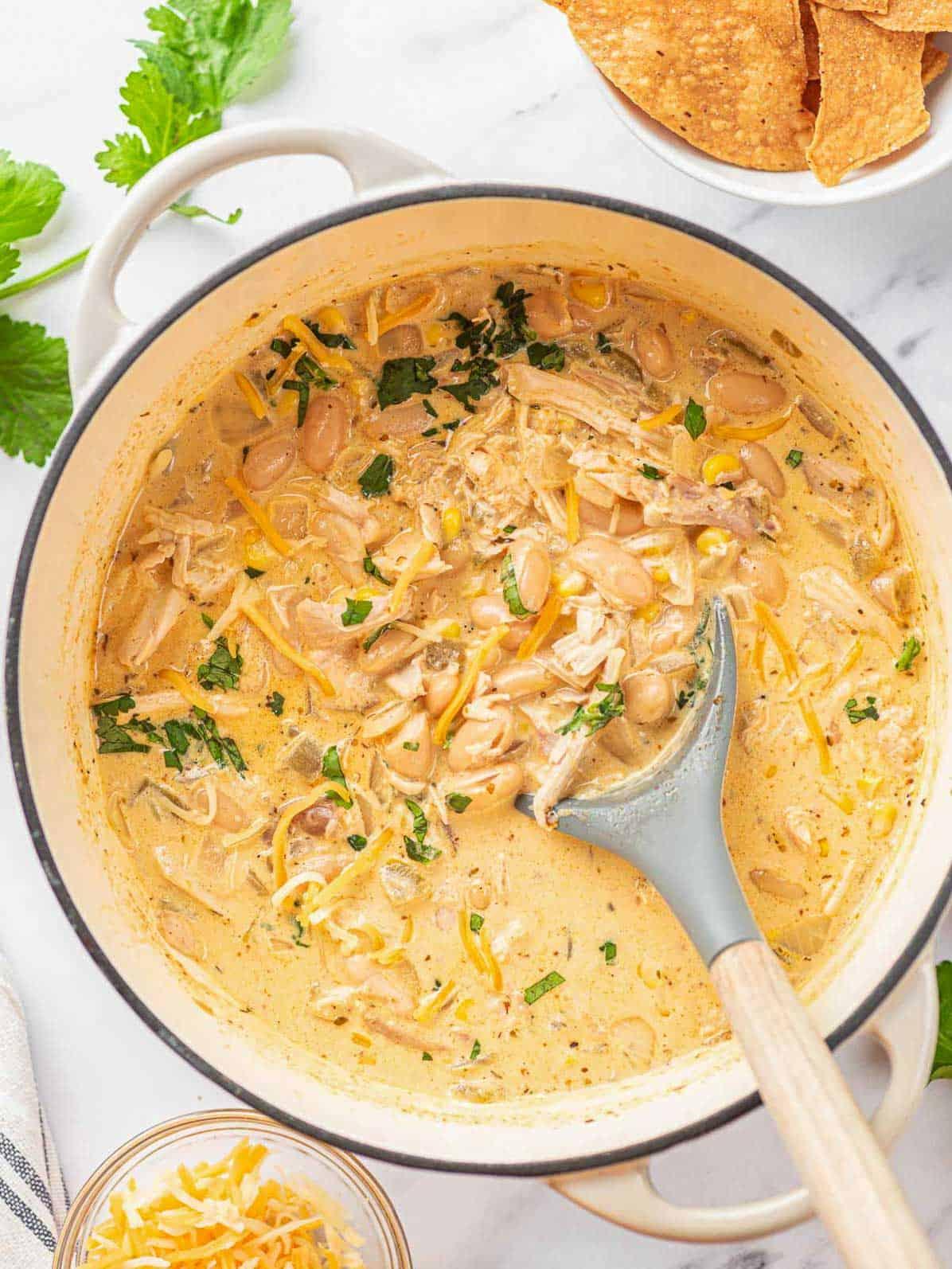 Close-up of creamy white chicken chili simmering in a dutch oven