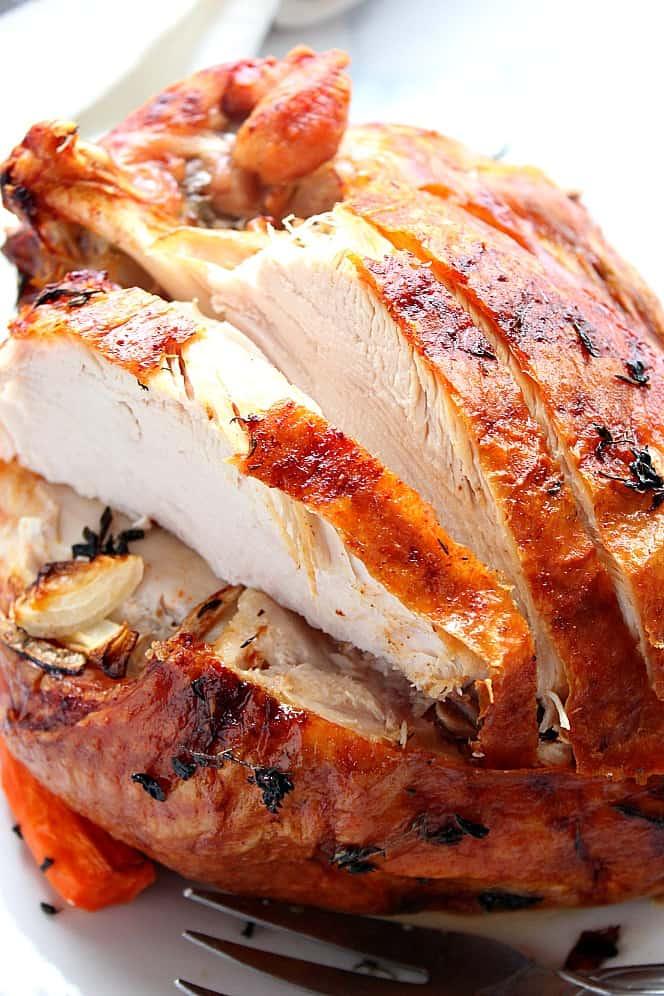 close-up of a golden roasted turkey breast with herbs and crispy skin