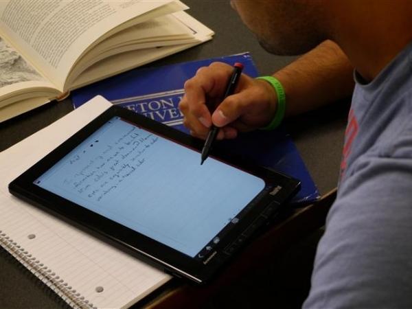 student using tablet for note taking in class