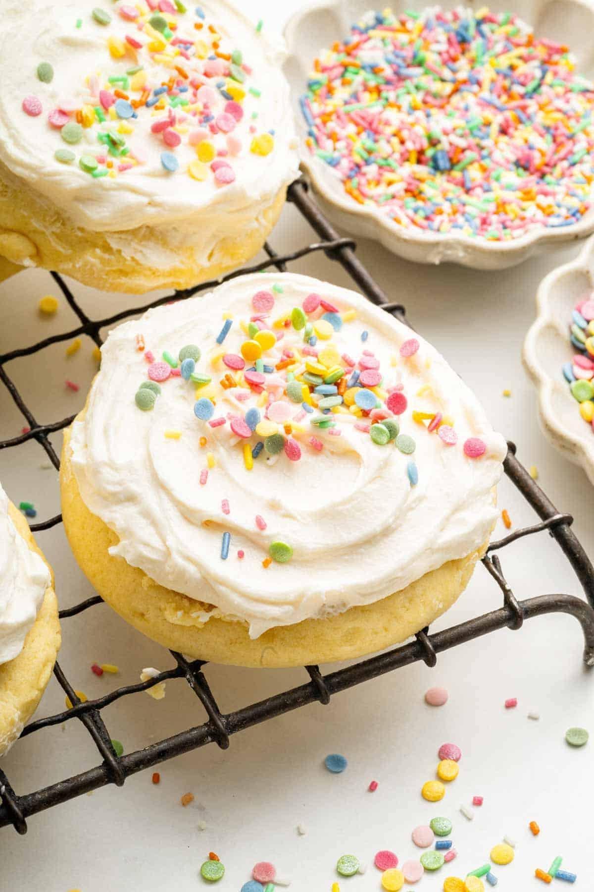 Delicious sugar cookies with vanilla frosting swirls on a cooling rack, natural light