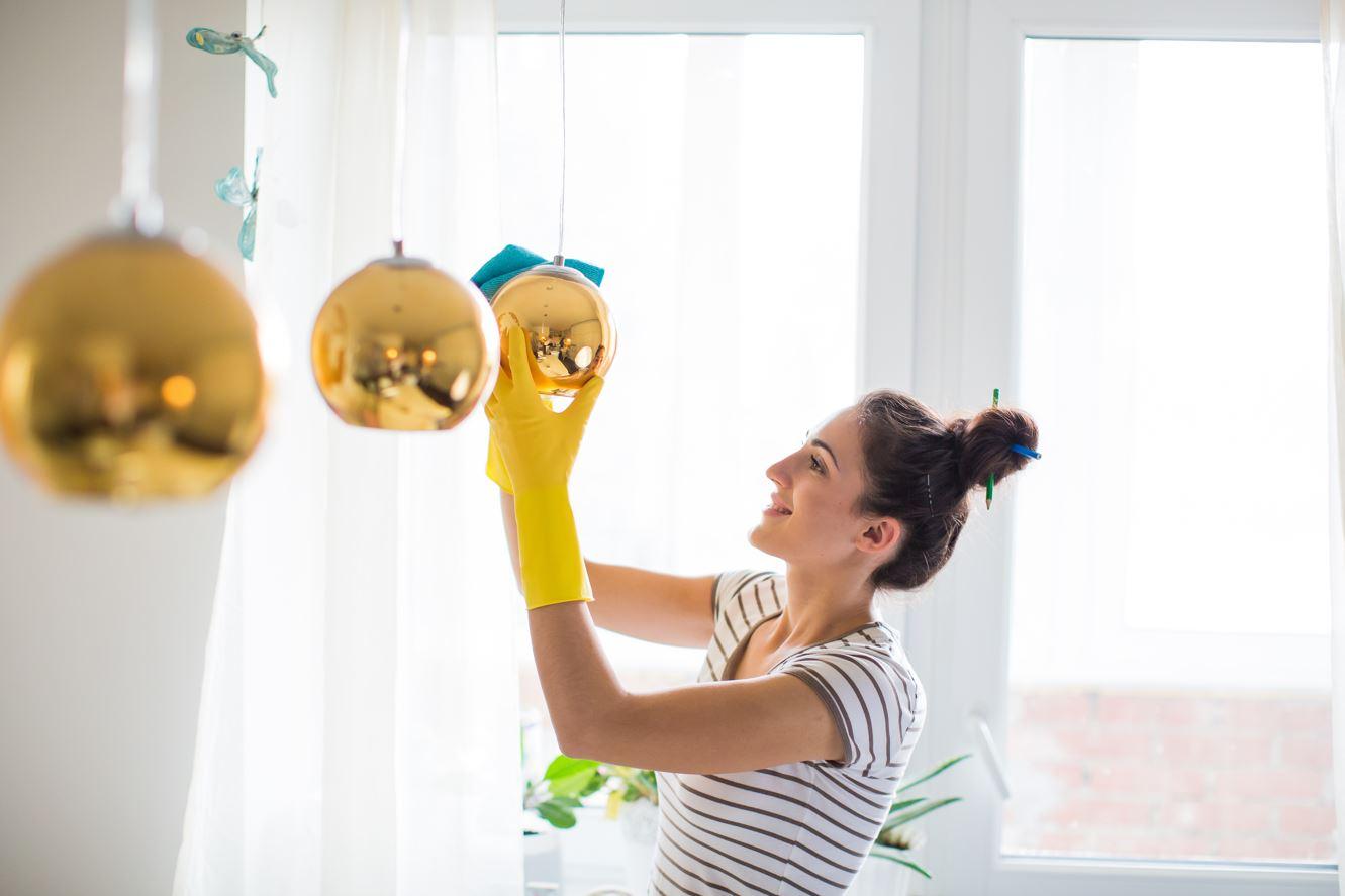 woman cleaning windows and light fixtures
