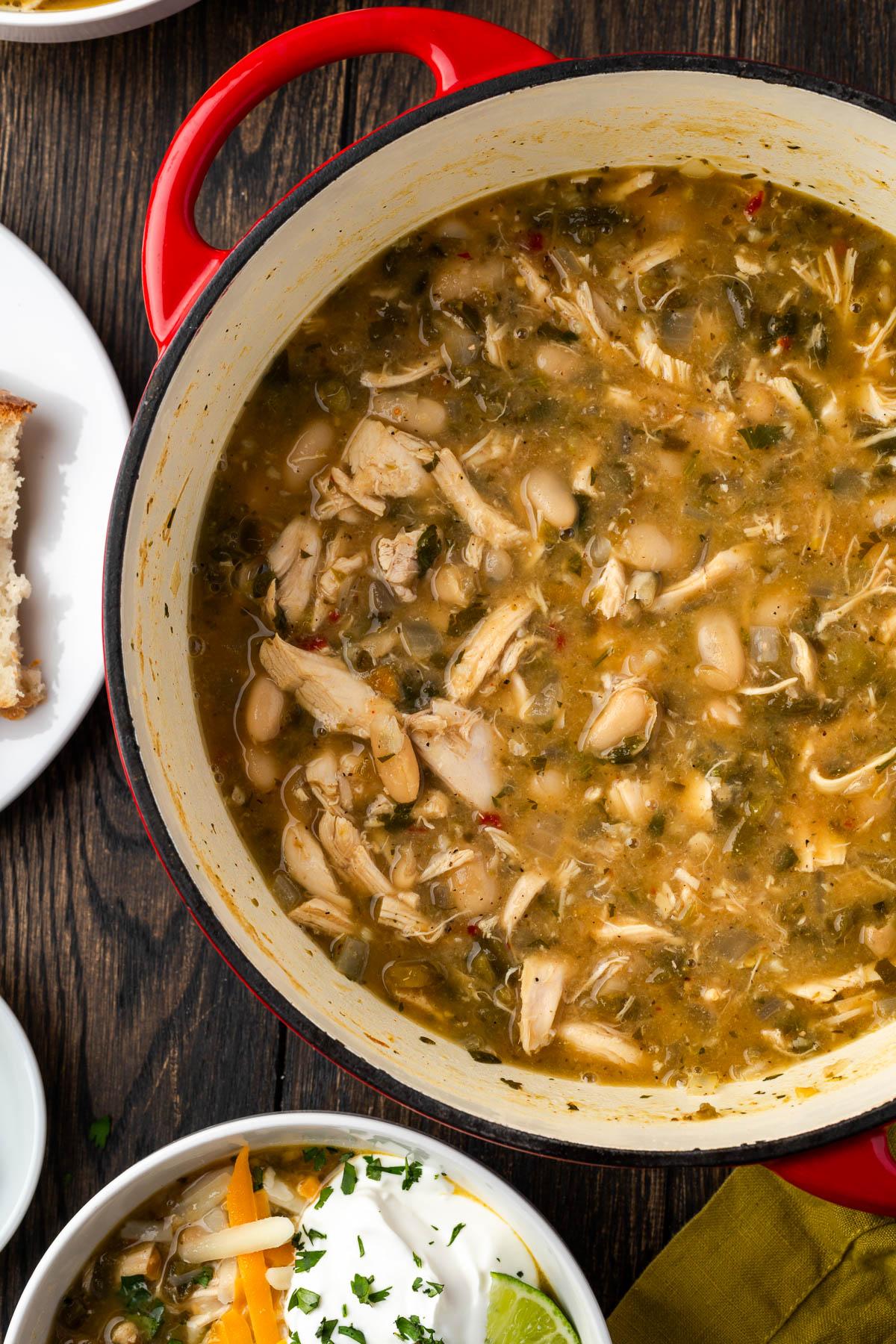 close-up of white chicken chili being stirred in a dutch oven
