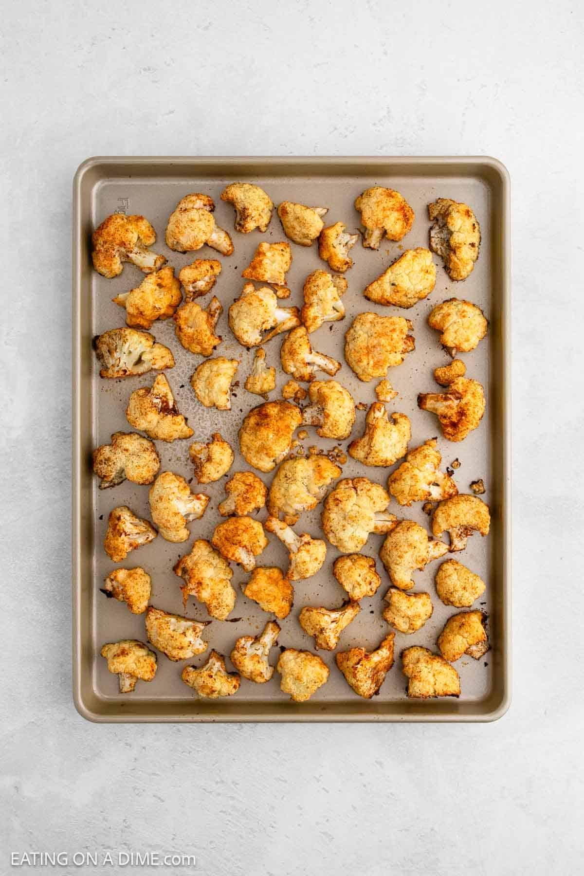 close-up of roasted cauliflower and leeks on a baking sheet, golden brown and slightly caramelized