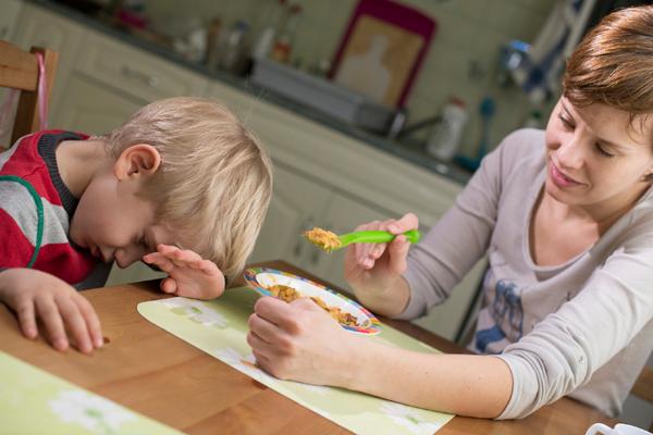 frustrated parent trying to feed a child
