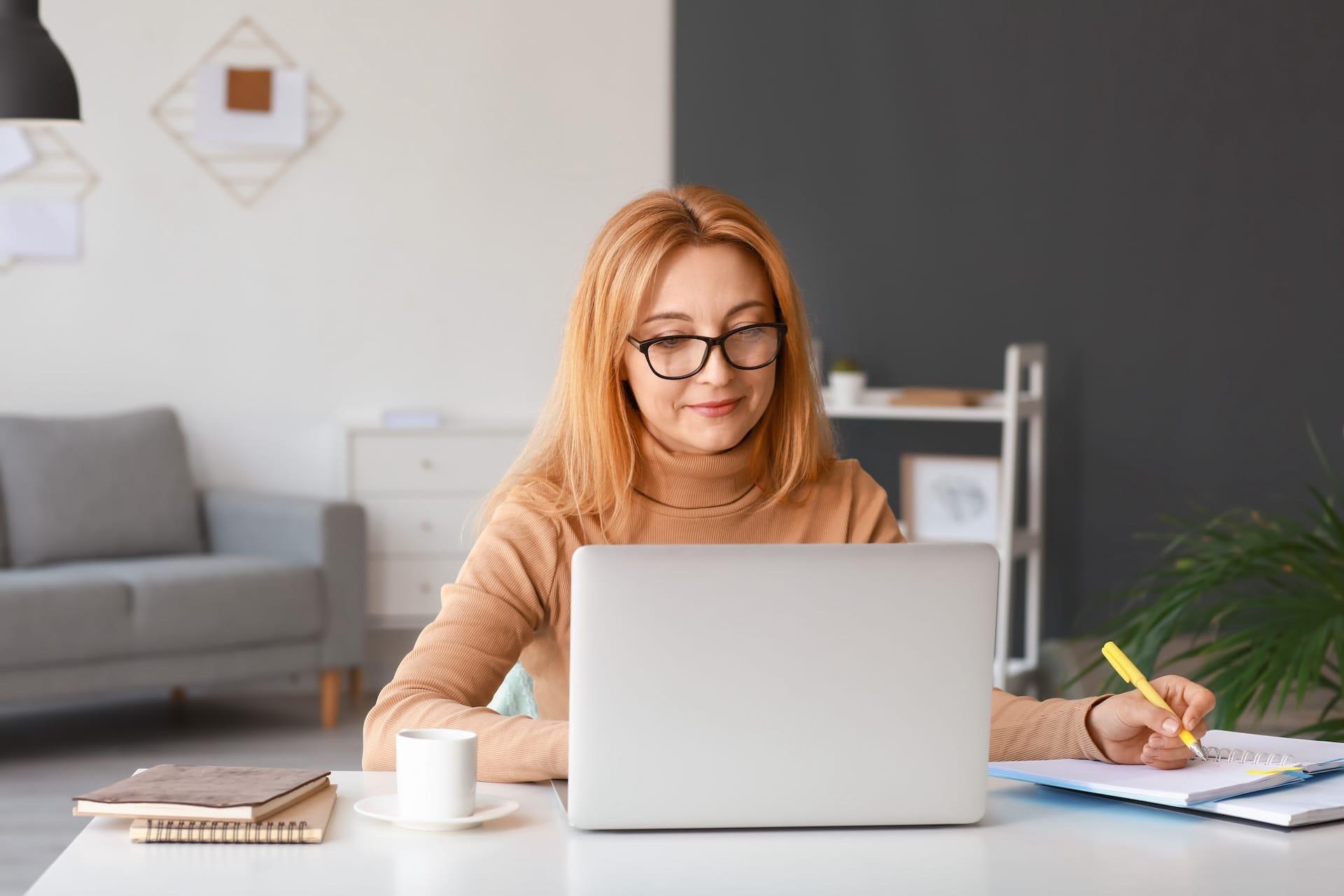 woman happily analyzing youtube analytics on laptop
