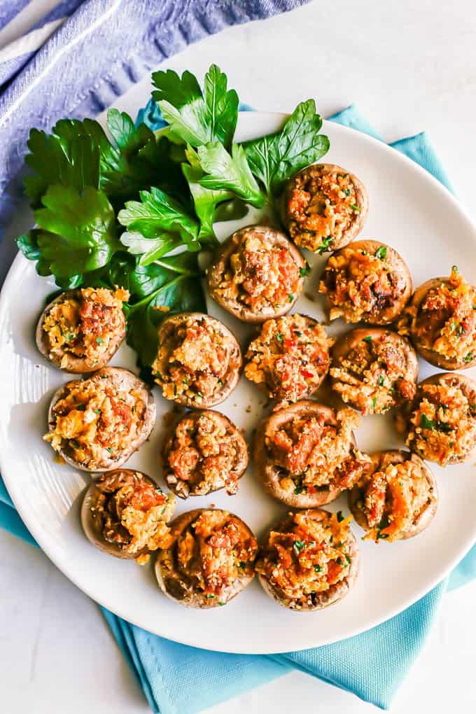 Overhead shot of a platter of freshly baked sausage stuffed mushrooms ready to serve