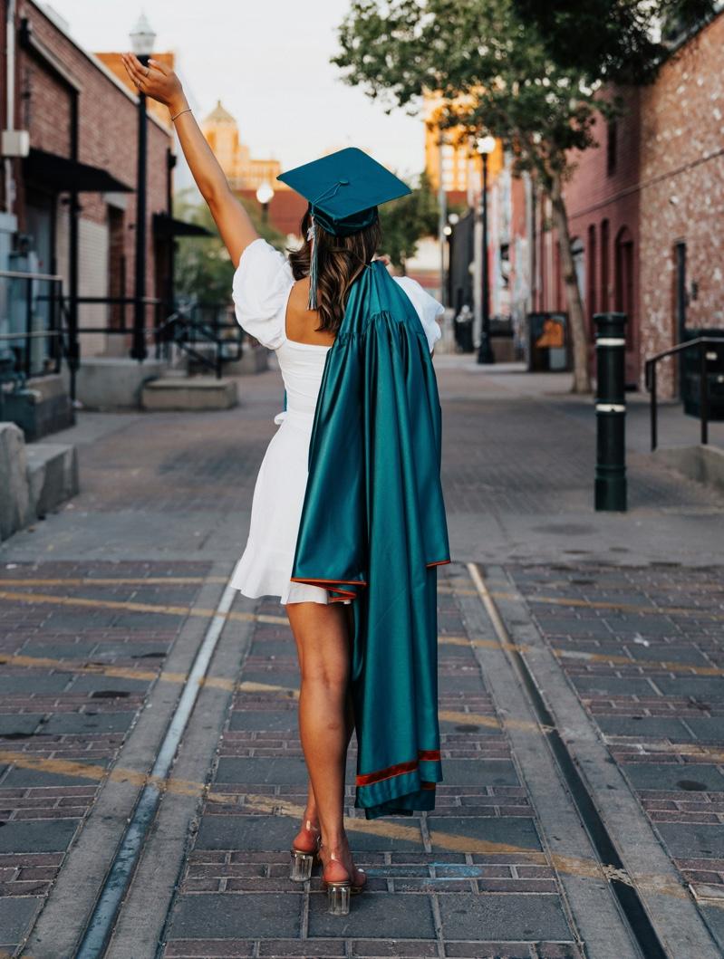 woman in a bold-colored graduation dress accessorized simply