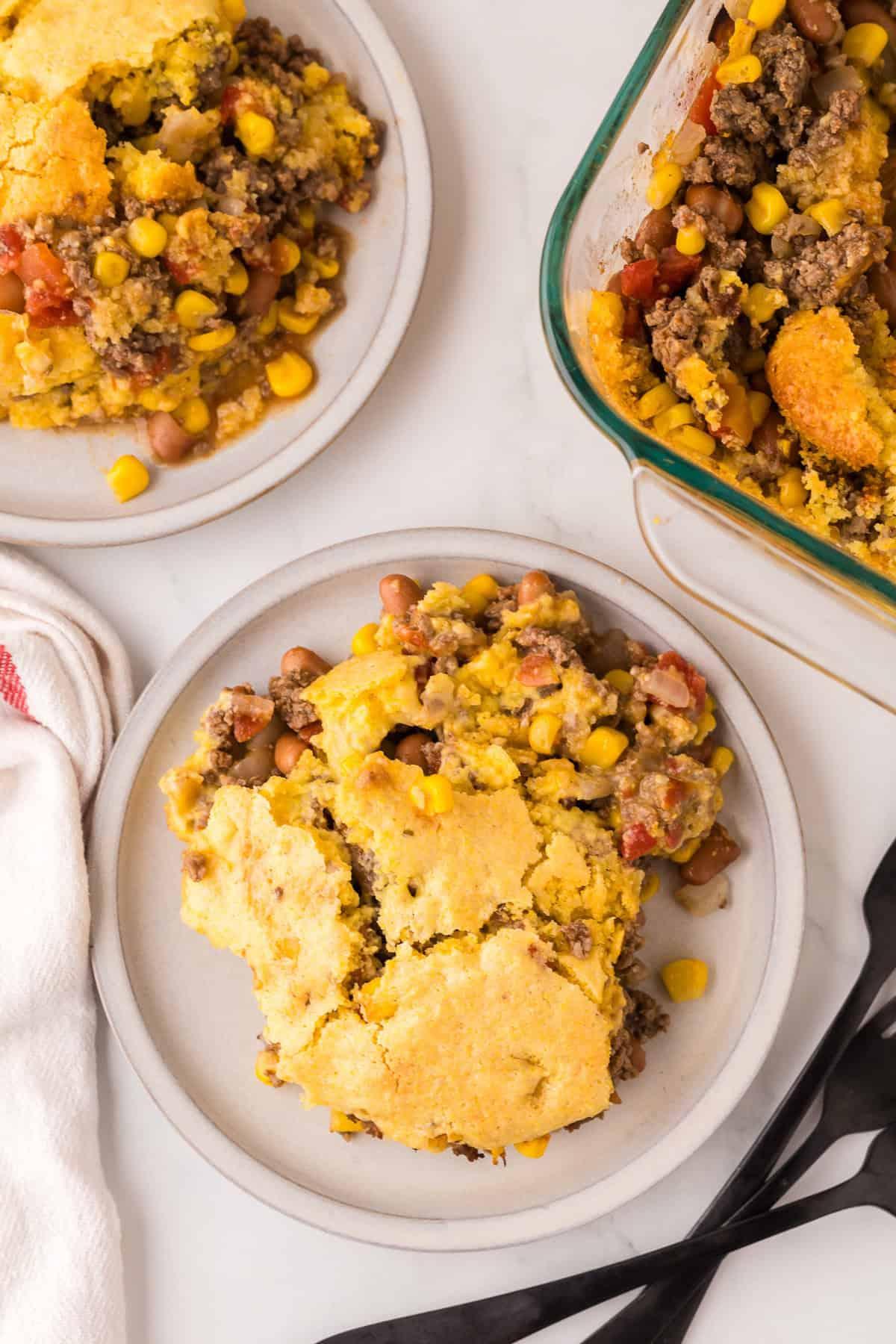 Cowboy casserole with ground beef, corn, and melted cheese topping in a rustic baking dish