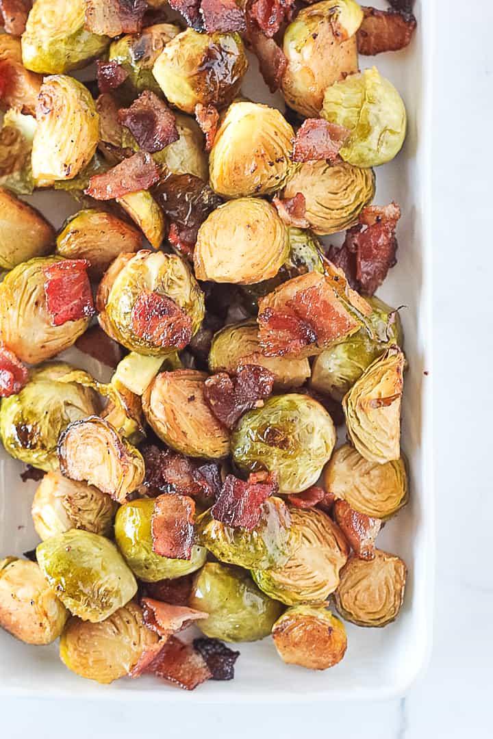 Close-up of a baking sheet filled with golden brown, roasted Brussels sprouts fresh out of the oven