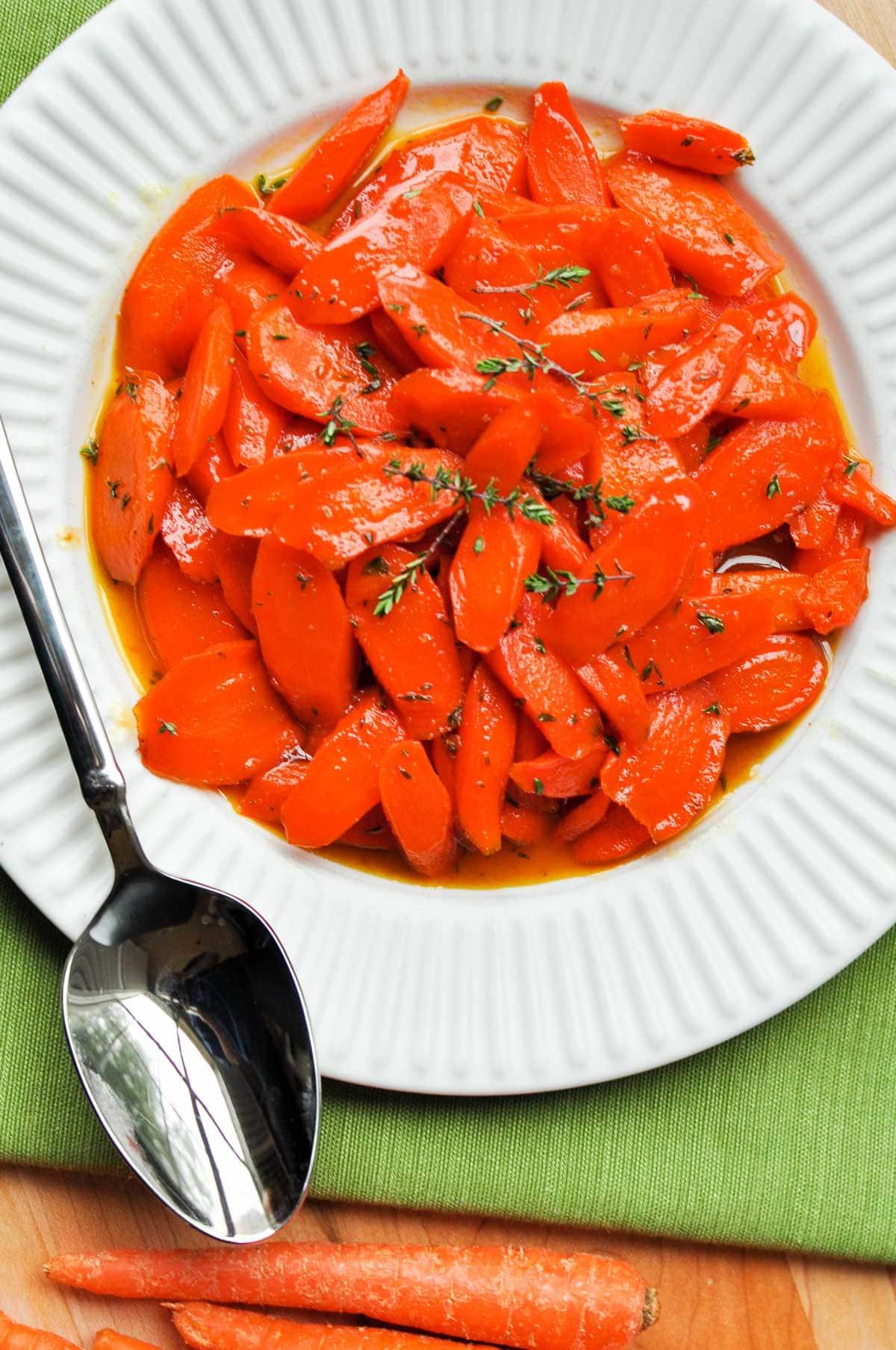 overhead shot of a large skillet with honey glazed carrots simmering gently