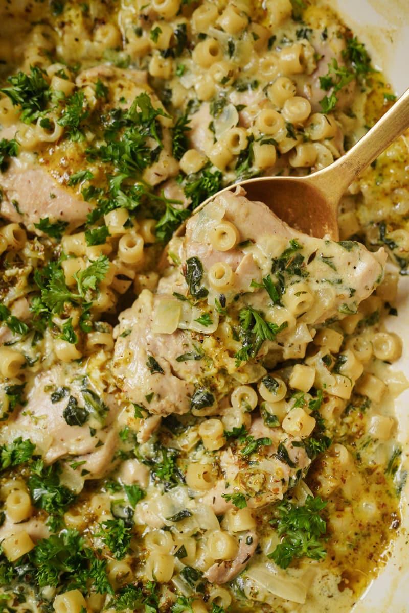 Close-up shot of a spoonful of Chicken Parmesan Mac and Cheese being lifted, showcasing the creamy texture and chicken pieces