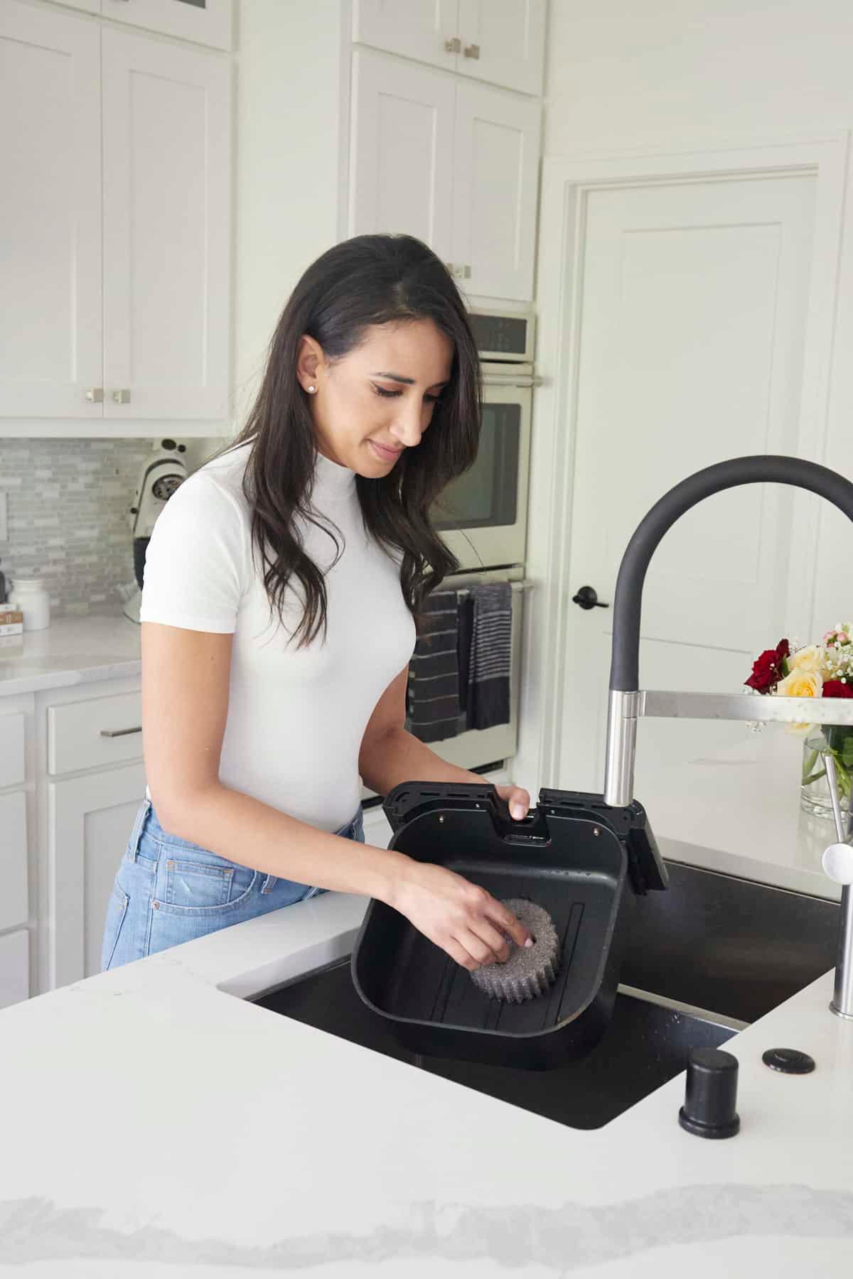 woman cleaning an air fryer