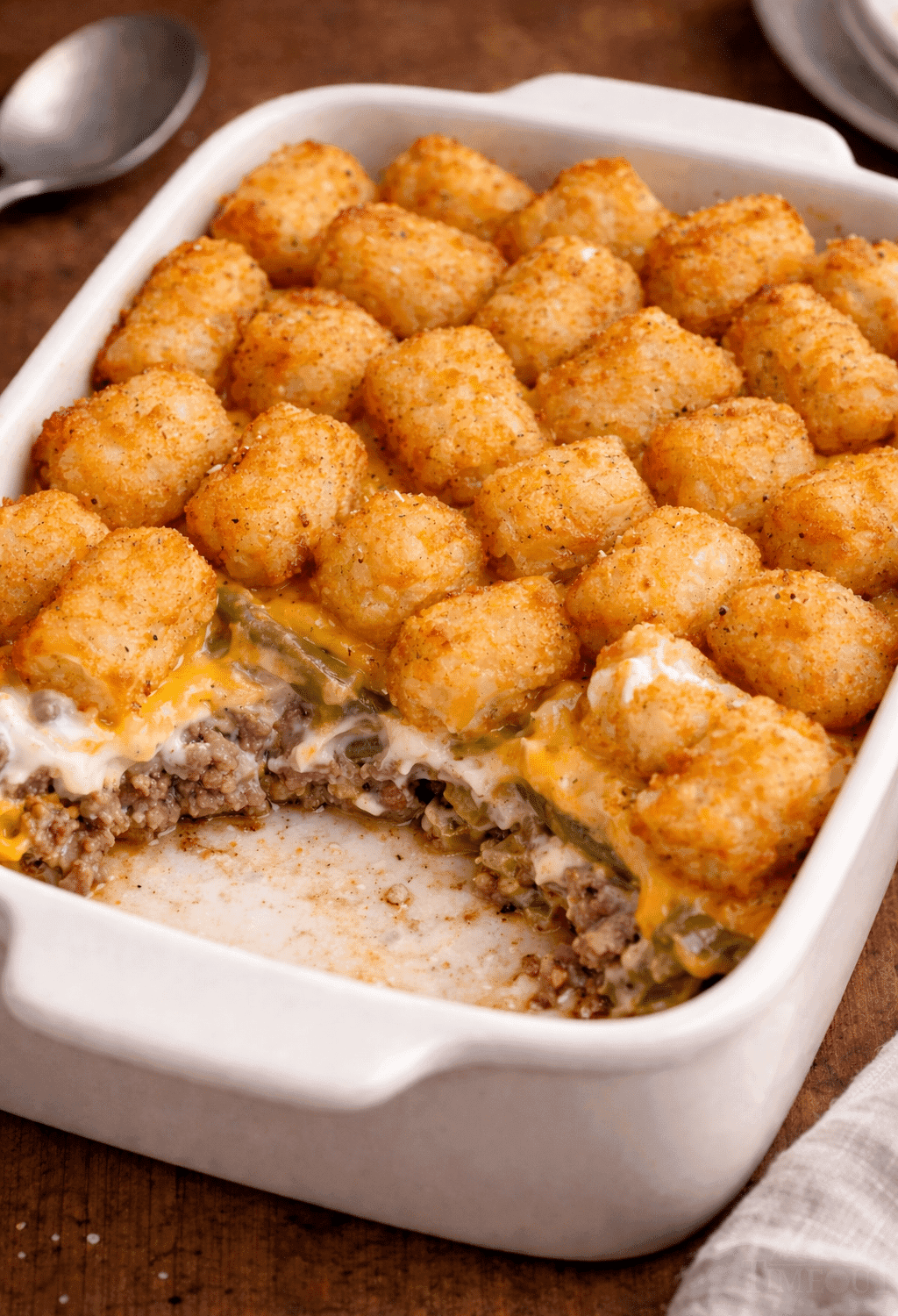 Golden crispy tater tots topping a bubbling casserole dish, steam rising