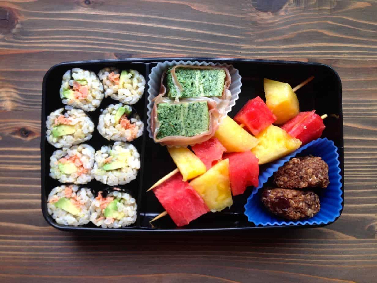 open avocado prosciutto bento box on a desk at work