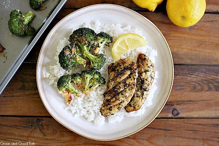 lemon herb roasted chicken with broccoli on a wooden table