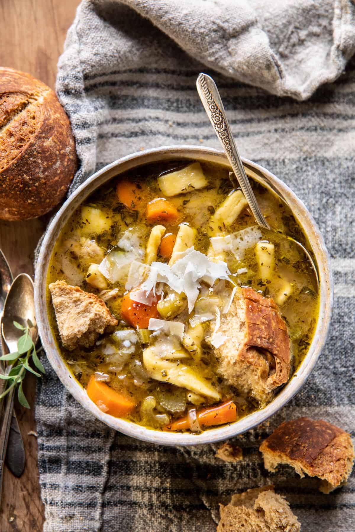 steaming cozy chicken noodle bowl with herbs and crusty bread