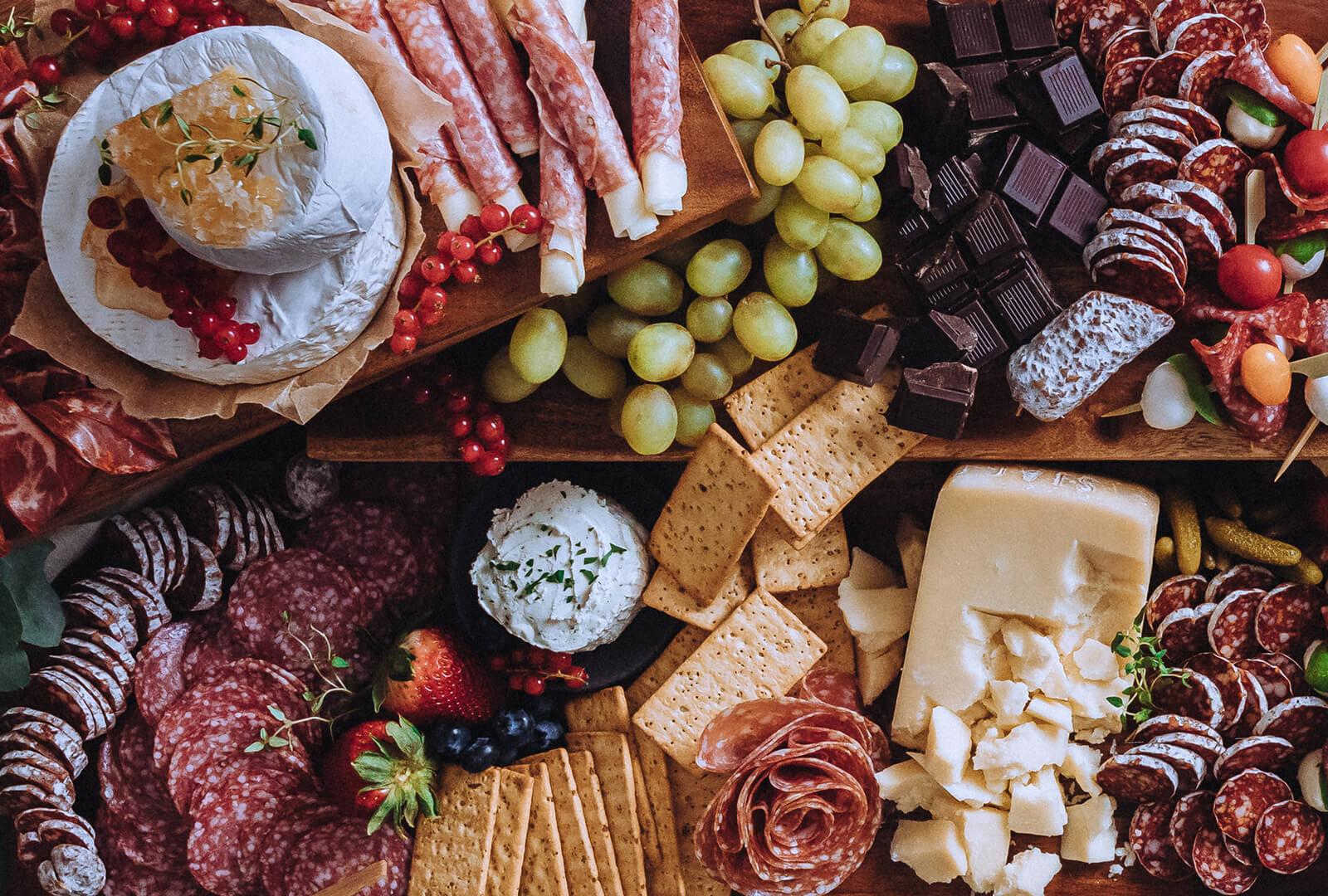 Close-up of a hand reaching for a colorful vegetable stick from a garden charcuterie board