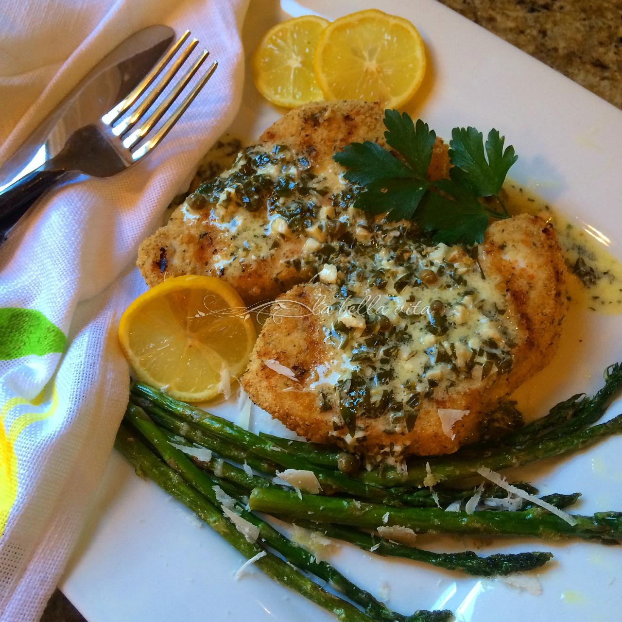 close up of a grilled swordfish steak being drizzled with lemon caper sauce