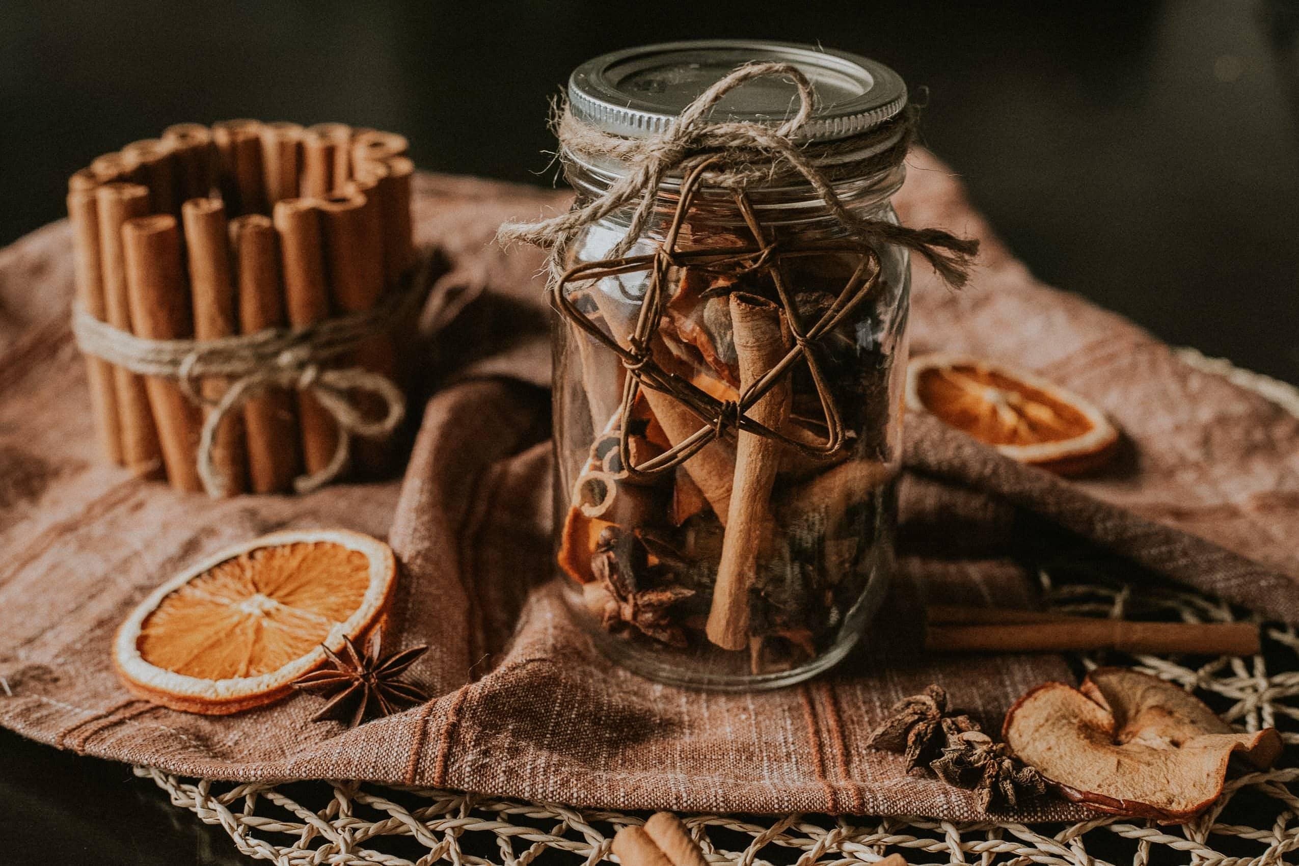 close-up of toasted whole spices like cinnamon sticks, star anise, and cloves on a baking sheet