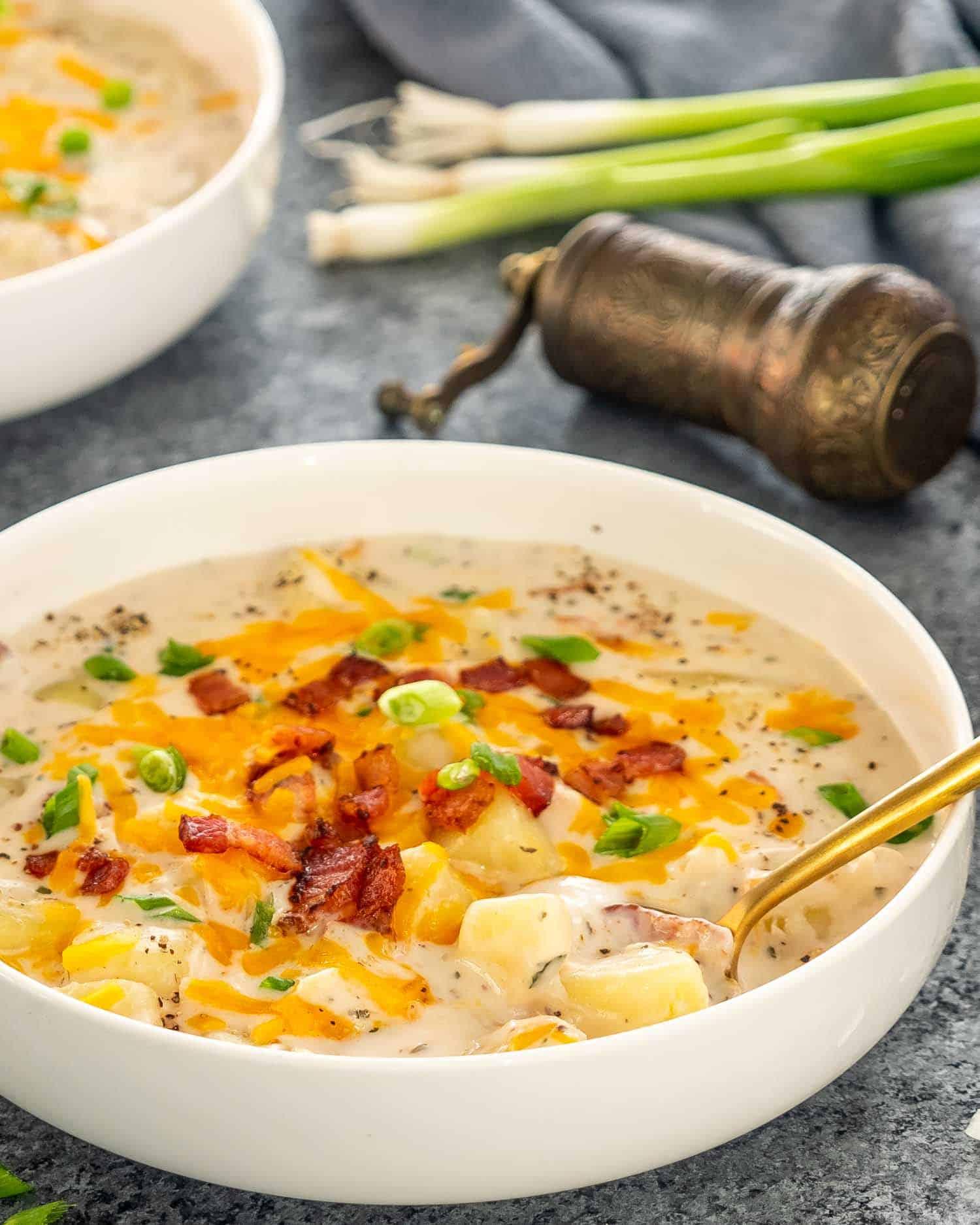 Creamy potato soup being poured into a white bowl
