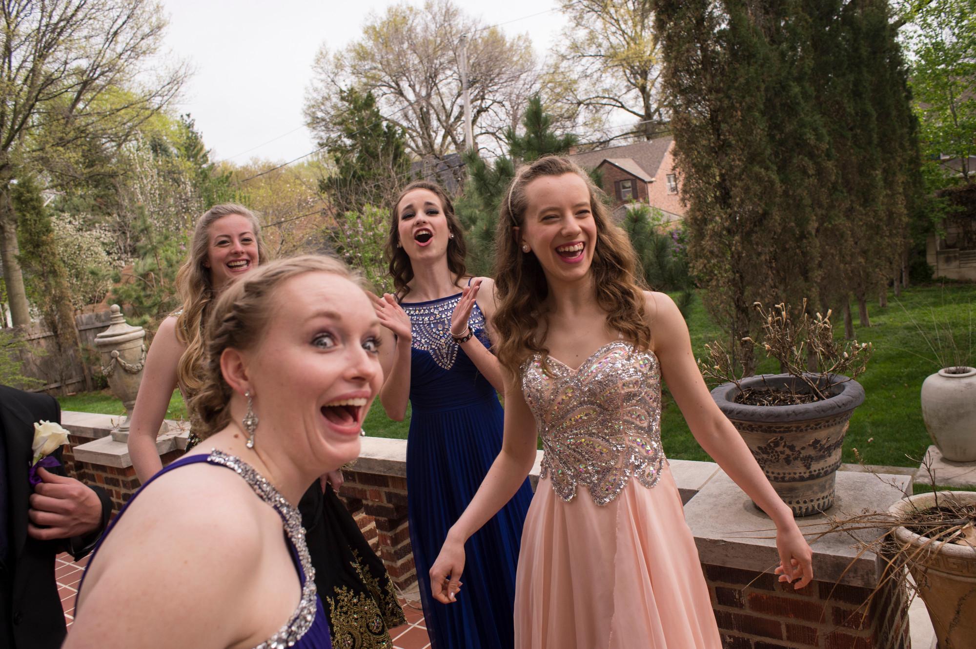group of teens posing for prom photos laughing