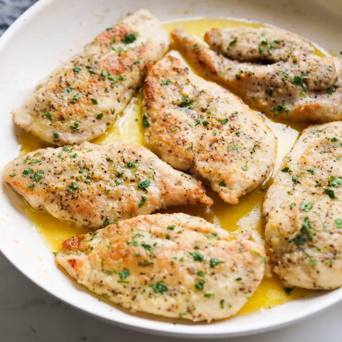 Close-up of sliced garlic-infused chicken breast revealing juicy interior, garnished with parsley