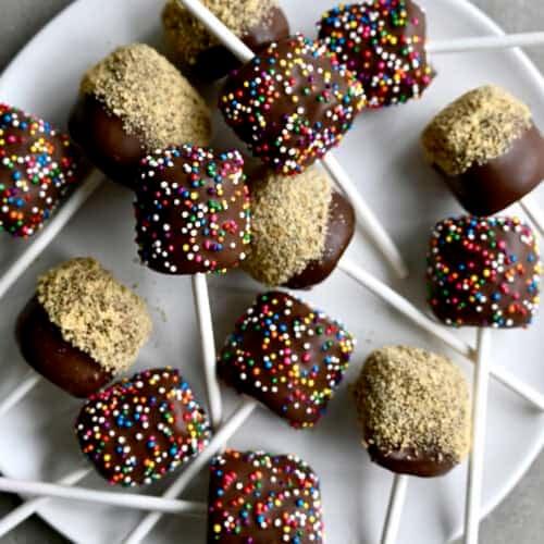 plate of chocolate-dipped marshmallows with festive sprinkles, close-up, soft lighting